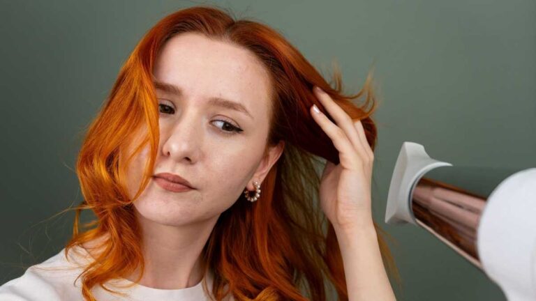 mulher ruiva usando secador de cabelo