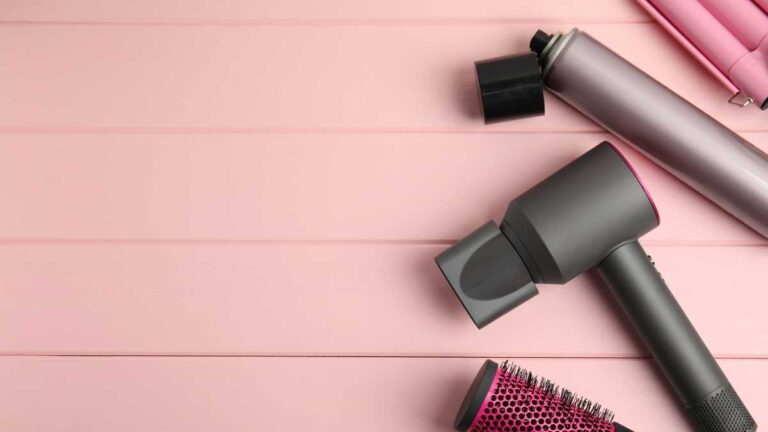 secador de cabelo preto ao lado de outros acessórios de beleza